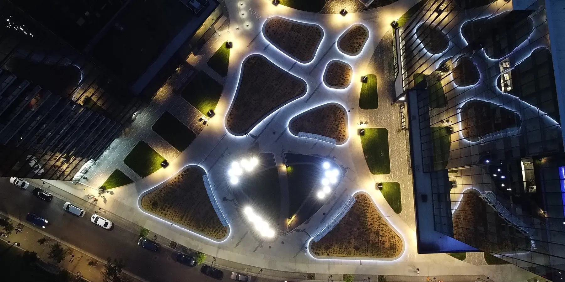 Night aerial view of K.W. Nasser Plaza illuminated between the towers